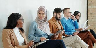 Multiethnische Personengruppe auf Stühlen sitzend