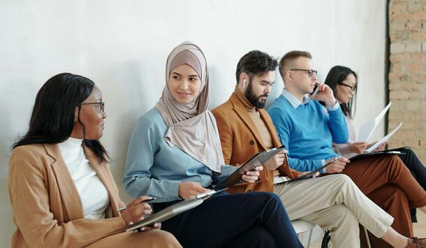 Multiethnische Personengruppe auf Stühlen sitzend