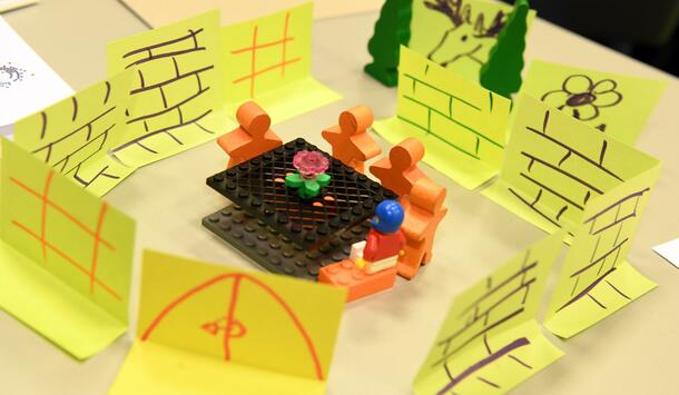 Spielfiguren in einem Raum aus Klebezetteln (Foto: Peter Himsel)