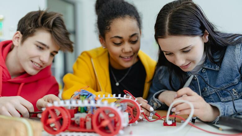 Schülergruppe bauen im Technikunterricht ein Fahrzeug 