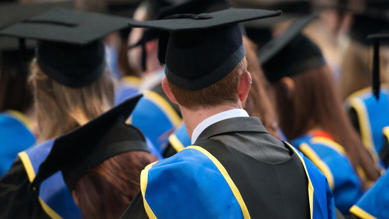 Foto: iStock/ Alan Barr Lincoln, UK, September 10, 2014. Students sit in a row at their university graduation ceremony